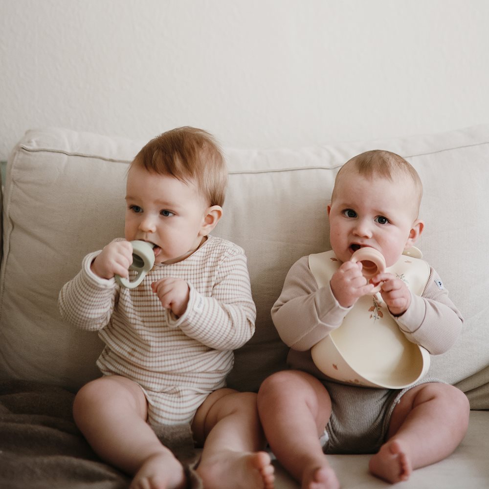 Mushie - Silicone Food Feeder - Sage - baby on sofa