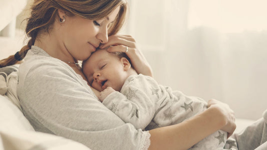 mama cuddling baby as a newborn baby on the sofa