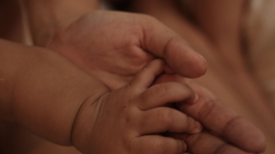 baby holding mothers hand, skin to skin