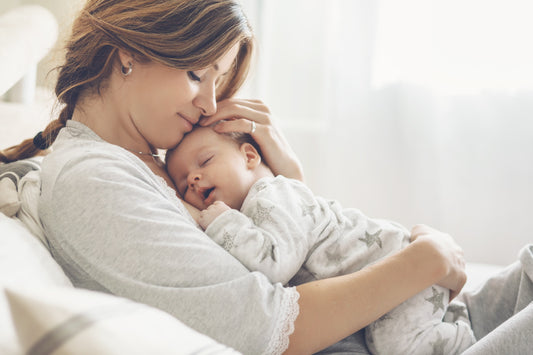 mama cuddling baby as a newborn baby on the sofa