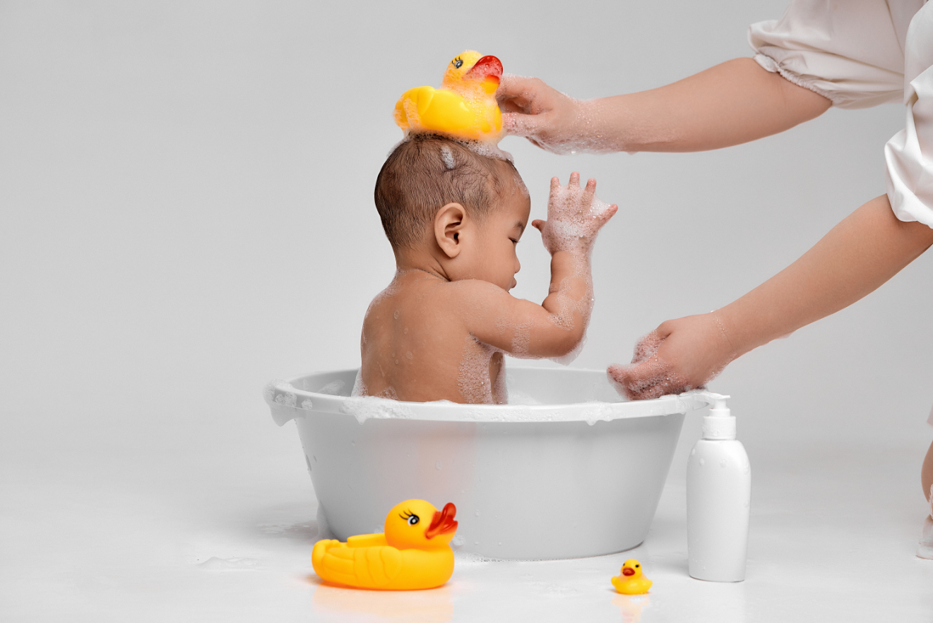 baby in bath with yellow ducks