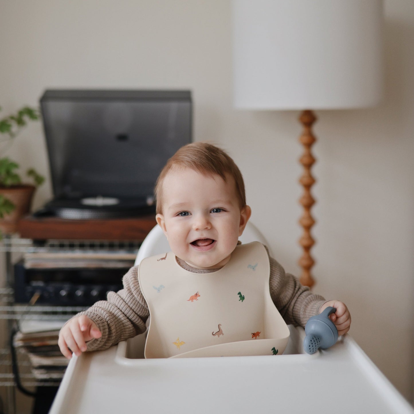 Mushie - Baby Silicone Bib - Dinosaurs - little boy smiling