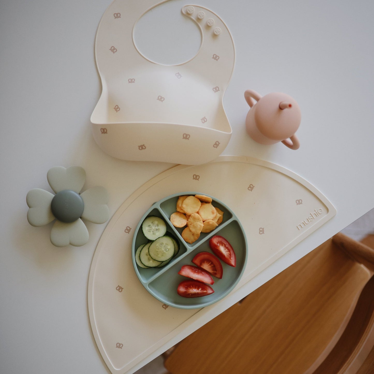 Mushie - Baby Silicone Bib - Pretzel - mat and green sage / pink accessories with food - toddler placemats non slip